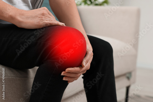 Woman suffering from rheumatism in knee at home, closeup