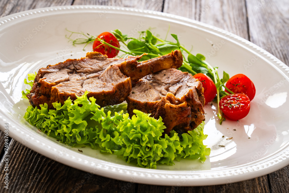 Lamb chops with bone and fresh vegetables on wooden table