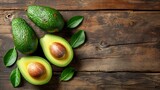 Avocado with leaves on wooden background, top view, copy space for text
