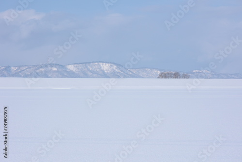深く雪に埋もれた川沿いの田んぼが生み出す、滑らかで美しい雪原風景 © acky.miya