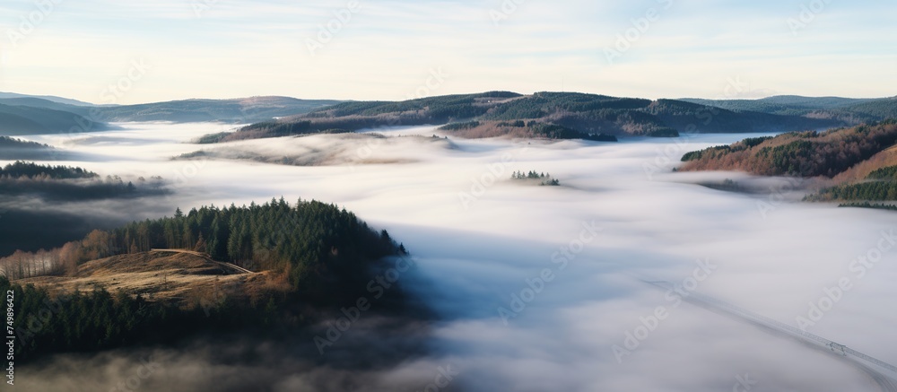 Aerial view of mountain peak with green trees in fog Aerial view of mountain peak with green trees in fog