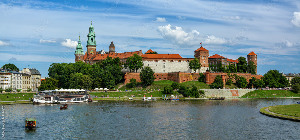 Obraz premium Front view of Wawel castle in Krakow, Poland with boats on Vistula river at summer time.