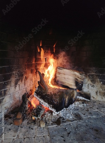 Wnętrze kominka z naturalnie palącym się drewnem dębowym. photo