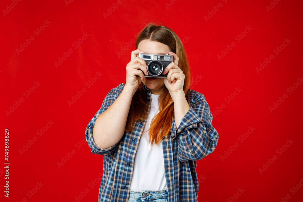 Young 30s photographer is taking a photo isolated over red background. Home hobby, lifestyle, travel, people concept Young 30s photographer is taking a photo isolated over red background. Home hobby, lifestyle, travel, people concept