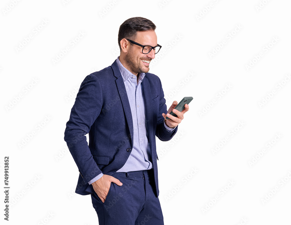 Portrait of male professional in glasses smiling and texting over mobile phone on white background