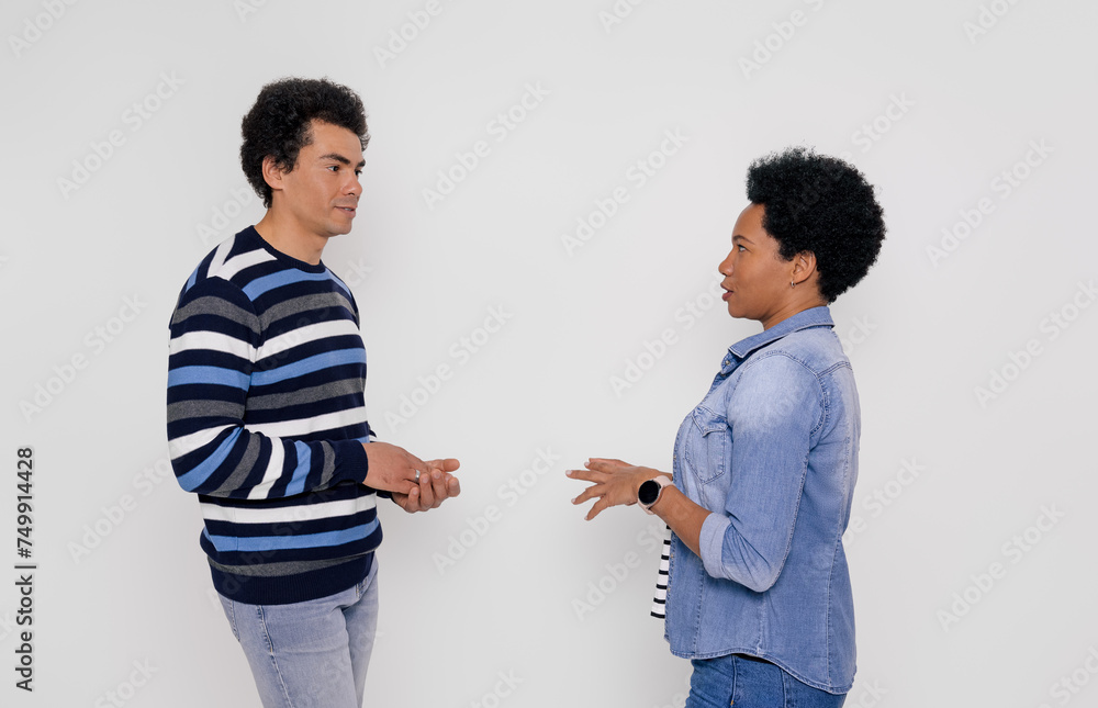 Side view of girlfriend and boyfriend talking with each other while standing on white background Side view of girlfriend and boyfriend talking with each other while standing on white background