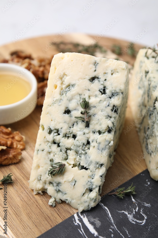 Tasty blue cheese with thyme, honey and walnuts on wooden board, closeup Tasty blue cheese with thyme, honey and walnuts on wooden board, closeup