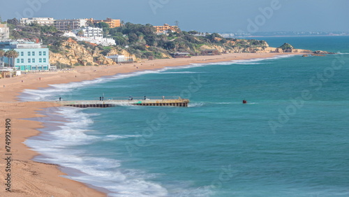 Wide sandy beach and Atlantic ocean in city of Albufeira timelapse. Algarve, Portugal