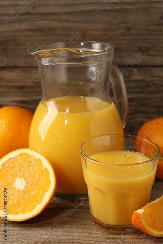 Tasty fresh oranges and juice on wooden table, closeup