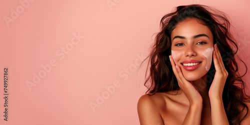 Attractive model woman takes care of her skin with copy space on brownish pink background.