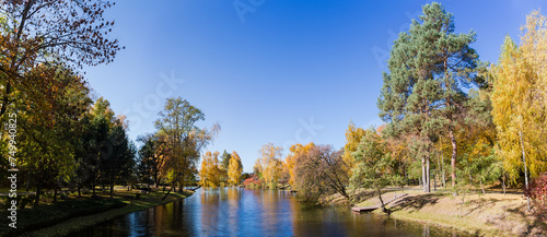 Scenic lake with different trees on banks in autumn park