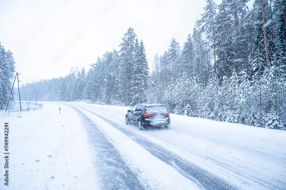 Car on the road in winter forest. Snowfall in Finland. Car on the road in winter forest. Snowfall in Finland.