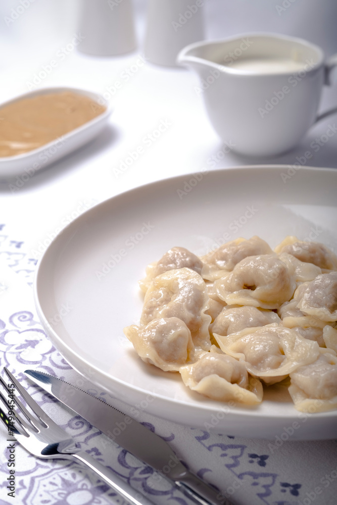 cooked dumplings in a white plate on a served table vertical image