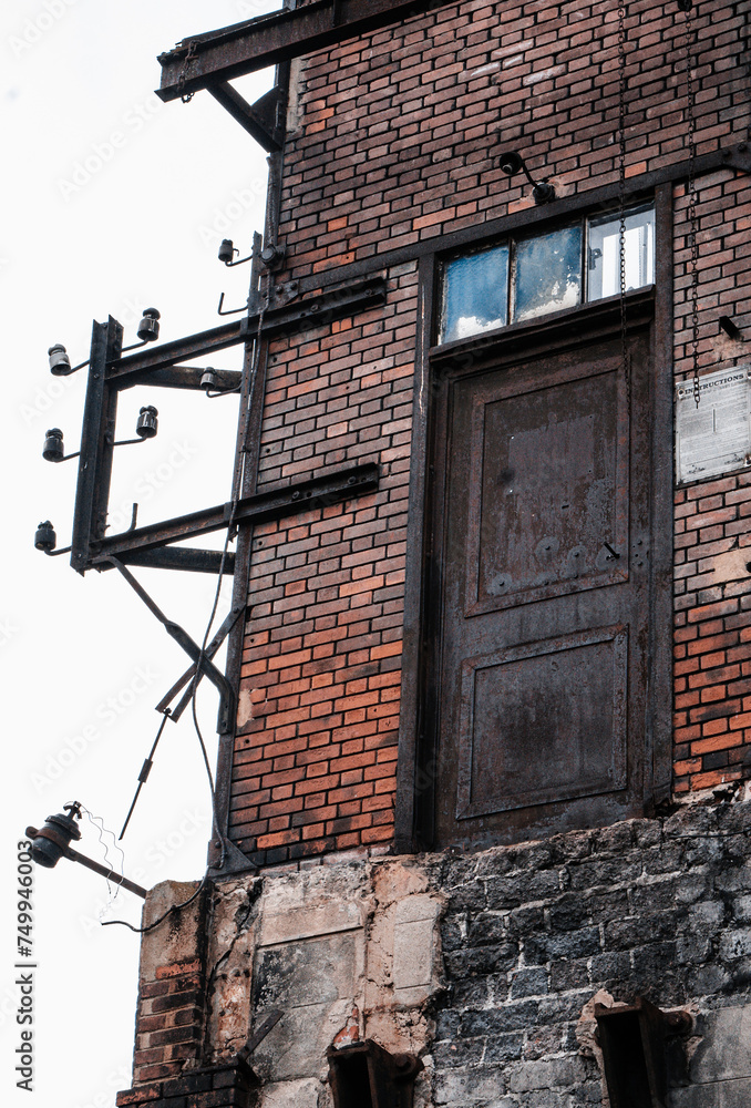 Bâtiment industrielle abandonné en brique d'une ancienne mine à charbon à Saint-Etienne avec une porte dans le vide