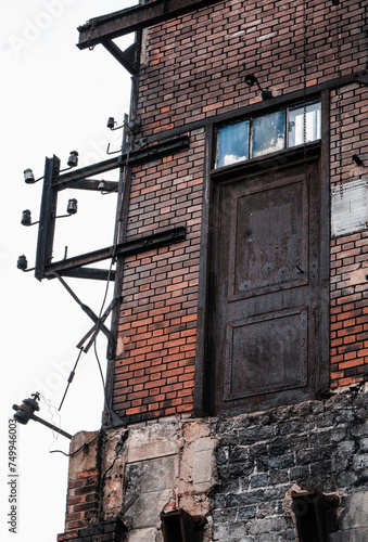 Obraz na płótnie Bâtiment industrielle abandonné en brique d'une ancienne mine à charbon à Saint-Etienne avec une porte dans le vide w salonie
