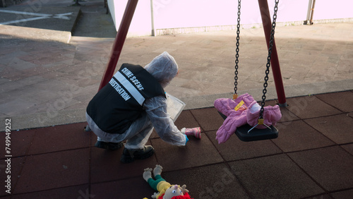 crime scene in a children's playground, where a child was kidnapped. the police present to catalog the evidence. swing and games seized.