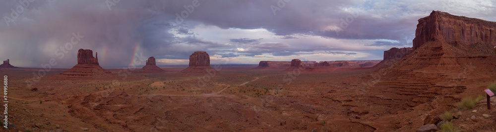 The Monument Valley Navajo Tribal Park in Arizona, USA. View of a storm and double rainbow over the West Mitten Butte, East Mitten Butte, and Merrick Butte Monuments.