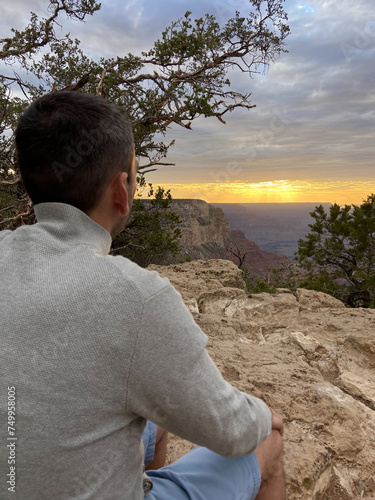 Obraz na płótnie A tourist man enjoying the view of the South Rim of the Grand Canyon National Park at sunset. w salonie