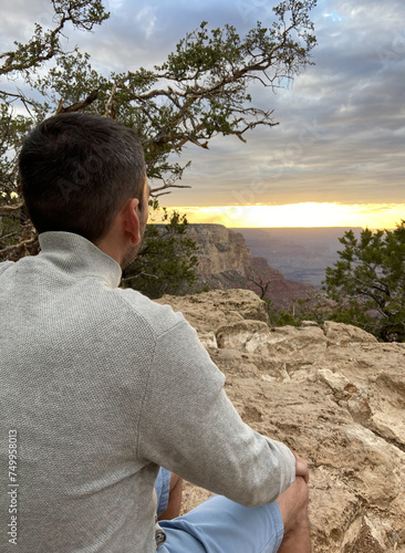 Obraz na płótnie A tourist man enjoying the view of the South Rim of the Grand Canyon National Park at sunset. w salonie