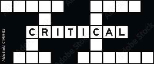 Alphabet letter in word critical on crossword puzzle background