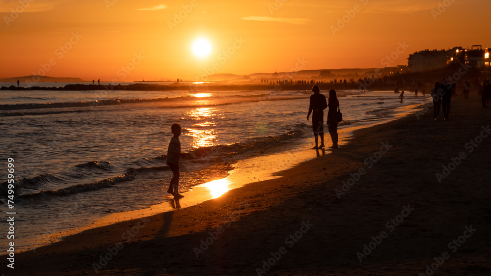 People enjoying the beach at sunset at Palavas les Flots, near Montpellier, France People enjoying the beach at sunset at Palavas les Flots, near Montpellier, France