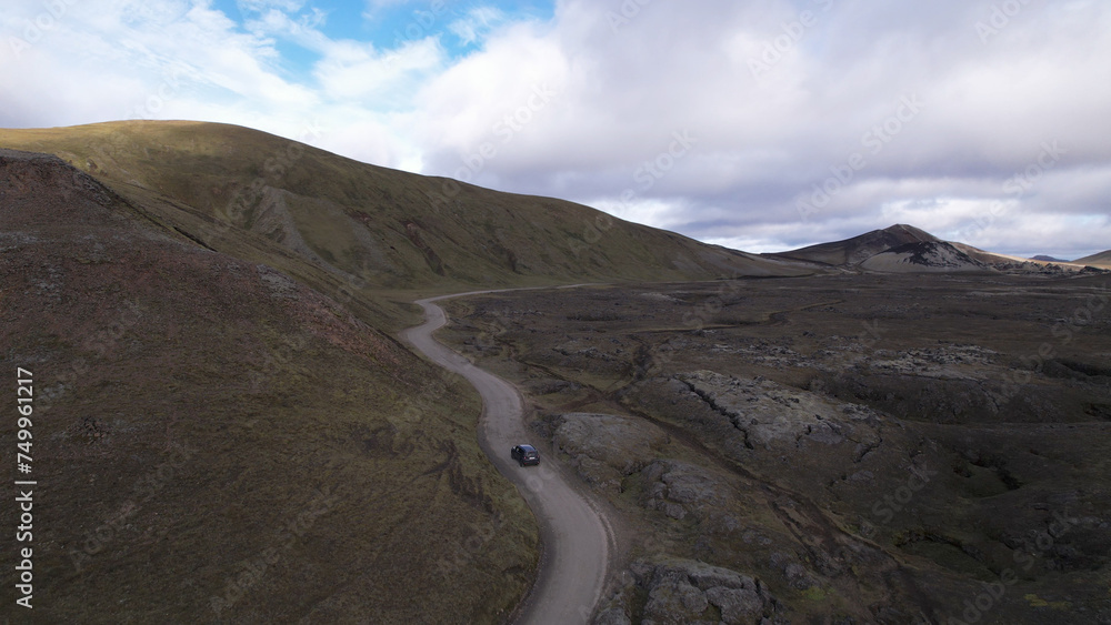 Car driving off-road terrain exploring the Fjallabak Natural Reserve. A 4x4 car driving dirt road traveling in Iceland sightseeing wilderness.