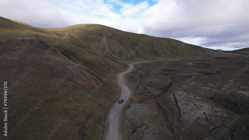 Car driving off-road terrain exploring the Fjallabak Natural Reserve. A 4x4 car driving dirt road traveling in Iceland sightseeing wilderness.