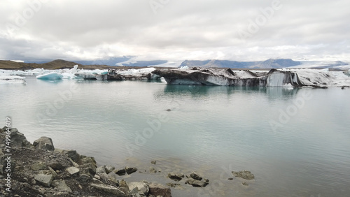 Floating icebergs in the Jökulsárlón Glacier Lagoon against cloudy sky, in southeast Iceland, on the edge of Vatnajökull National Park in Iceland. photo