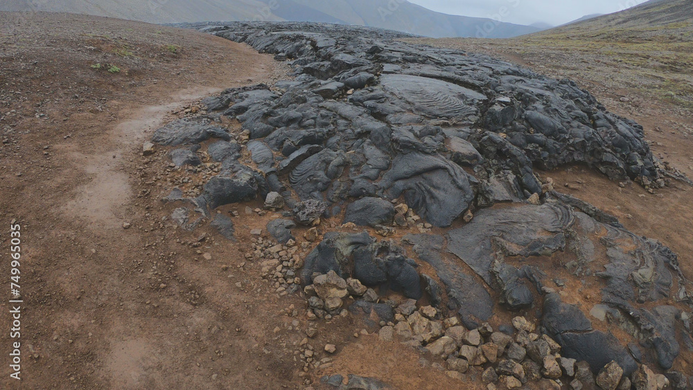View of cracked lava crust or ingenious rock and steam cooled down from the 2021 eruption of Fagradalsfjall volcano in Geldingadalir Valley on Reykjanes Peninsula in Iceland.