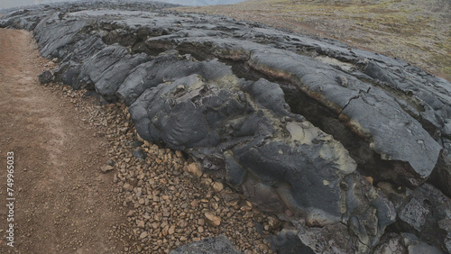 Obraz na płótnie View of cracked lava crust or ingenious rock and steam cooled down from the 2021 eruption of Fagradalsfjall volcano in Geldingadalir Valley on Reykjanes Peninsula in Iceland. w salonie