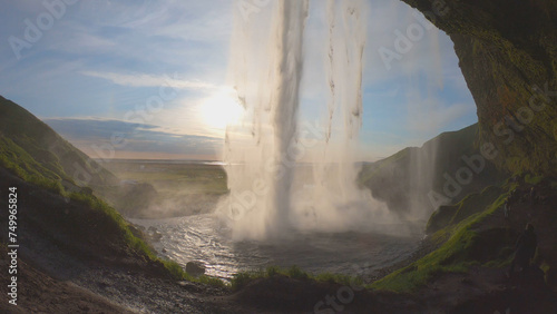 Obraz na płótnie The Seljalandsfoss waterfall on the south coast of Iceland bathed in the otherworldly light of the midnight sun. The waterfall drops 60 meters and is part of the Seljalands River. w salonie