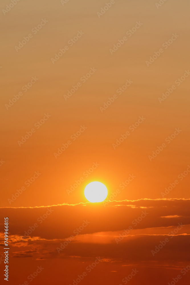 Sunset over the sea with orange sky and clouds, background.