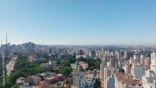 Filme aéreo de São Paulo aonde conseguimos ver a magnitude da cidade, com seus arranha-ceus, mas também com pequenas áreas verdes photo