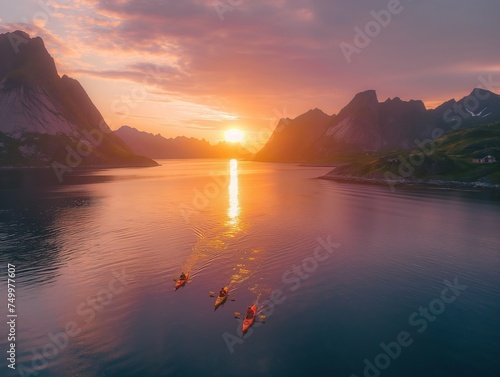 Aerial view of kayaks paddling towards the sunset in a serene coastal landscape with dramatic mountains