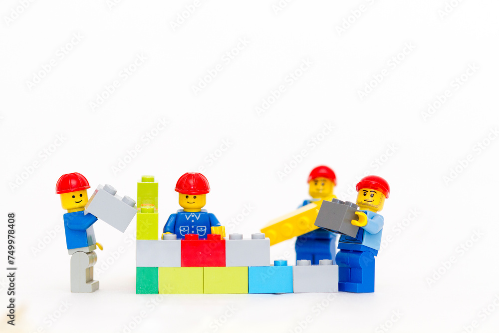Obraz premium Orvieto, Italy - January 16th 2015: team of workman Lego mini figure build a wall. Lego is a popular line of construction toys manufactured by the Lego Group