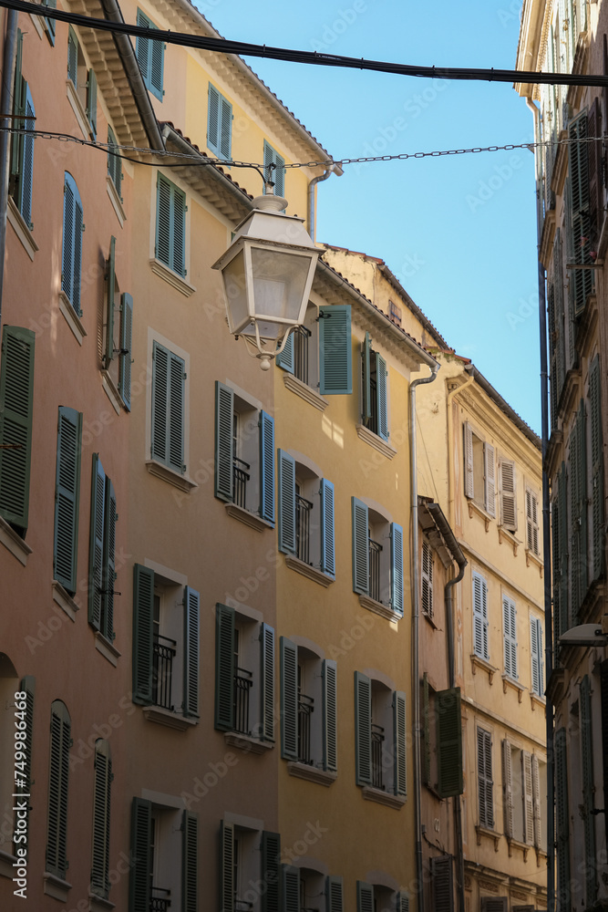 Romantic backstreet road alley in historic old town downtown Toulon, France with Mediterranean style house building facades and old little piazzas fountains picturesque city scenery