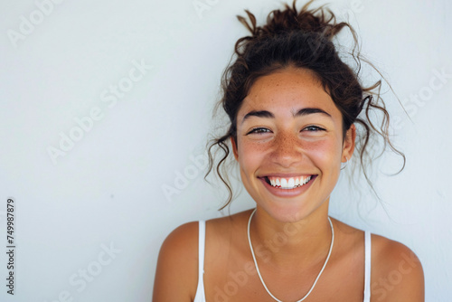 Portrait of a young ethnical woman smiling in front of a white background