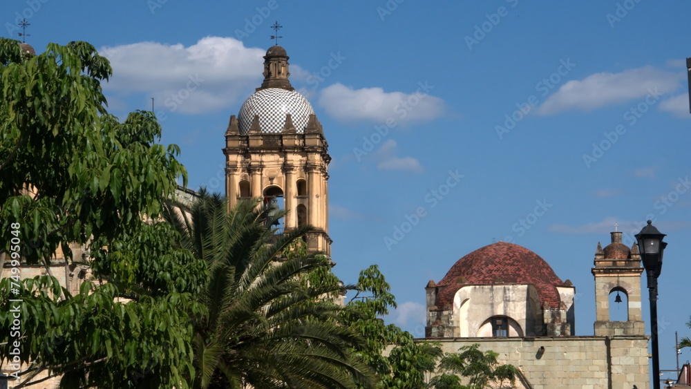 Tiled bell tower with trees below at the Church and Convent of Santo Domingo de Guzman in Oaxaca, Mexico