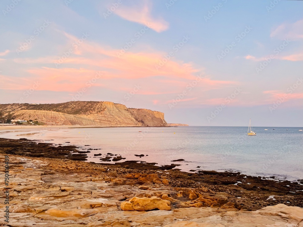 Natural pastel colors of the sky at the ocean, rocky ocean bay, purple heaven 