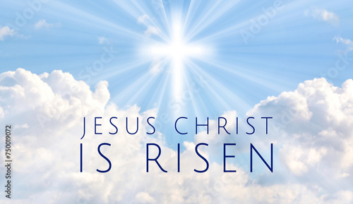 Easter illustration with the text 'Jesus Christ is Risen' and a shining cross on defocused blue sky with lightbeam.