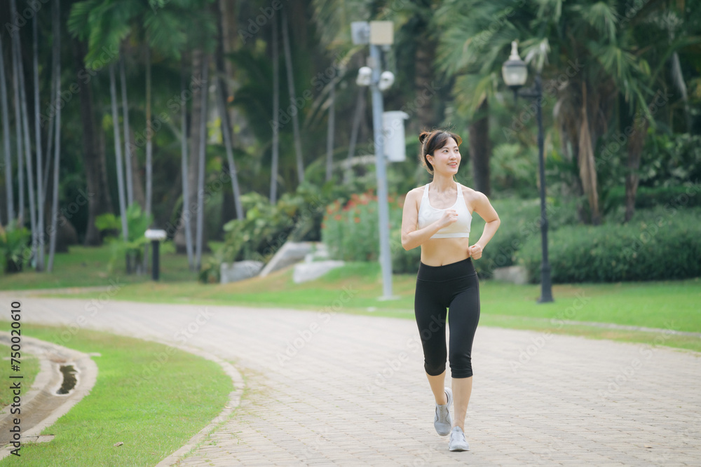 asian woman jogger running in green nature public park.