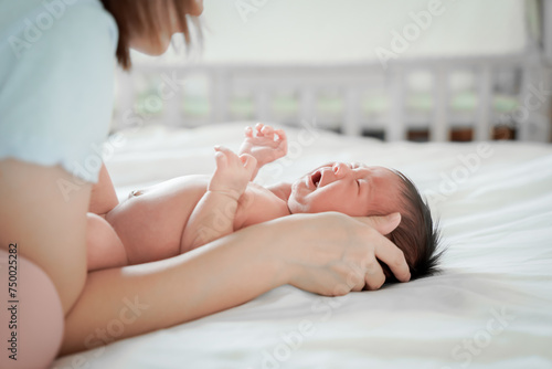Fotografi newborn male Is a person of Asian descent Lying in the bedroom on a white bed I'm crying