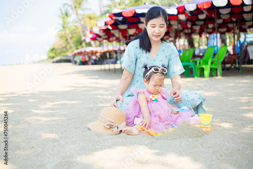 Mother and girl playing in the sand on the beach, Pattaya, Thailand,Mother with children playing with sand on beach