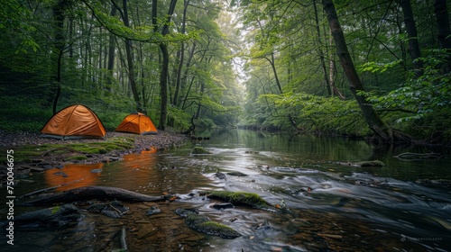 A camping riverside campsite with a lush green forest 