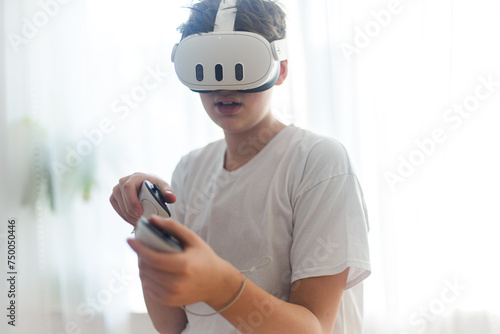 Teenage boy playing oculus console Meta Quest 3. Copy space. VR head set.