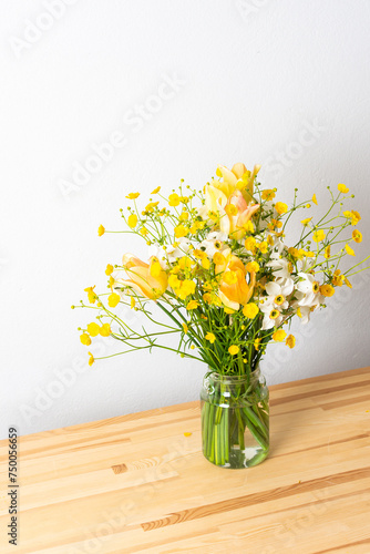 Wallpaper Mural Spring bouquet of yellow buttercups, white daffodils and tulips, bouquet of flowers on the table near the wall, home decoration with flowers Torontodigital.ca