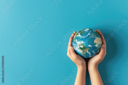 close up Hands holding earth globe  leaves and flowers on background  space for text  earth day
