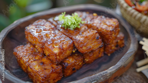Glazed tofu cubes on wooden plate