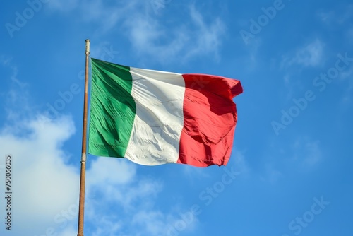 Large three colors Italian flag waving in the wind against sunny blue sky background