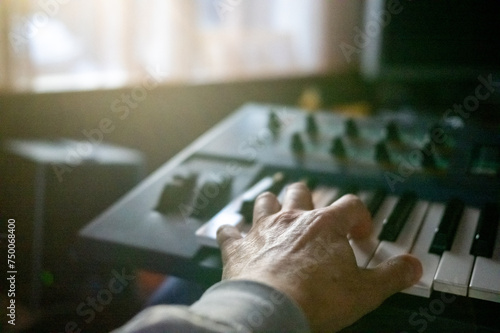 a hand of musician playing a digital keyboard, indoor shot